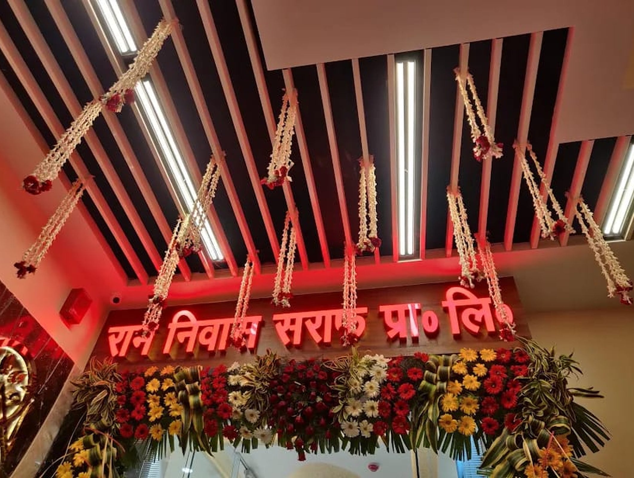 Ram Niwas Saraf signboard decorated with flowers and garlands