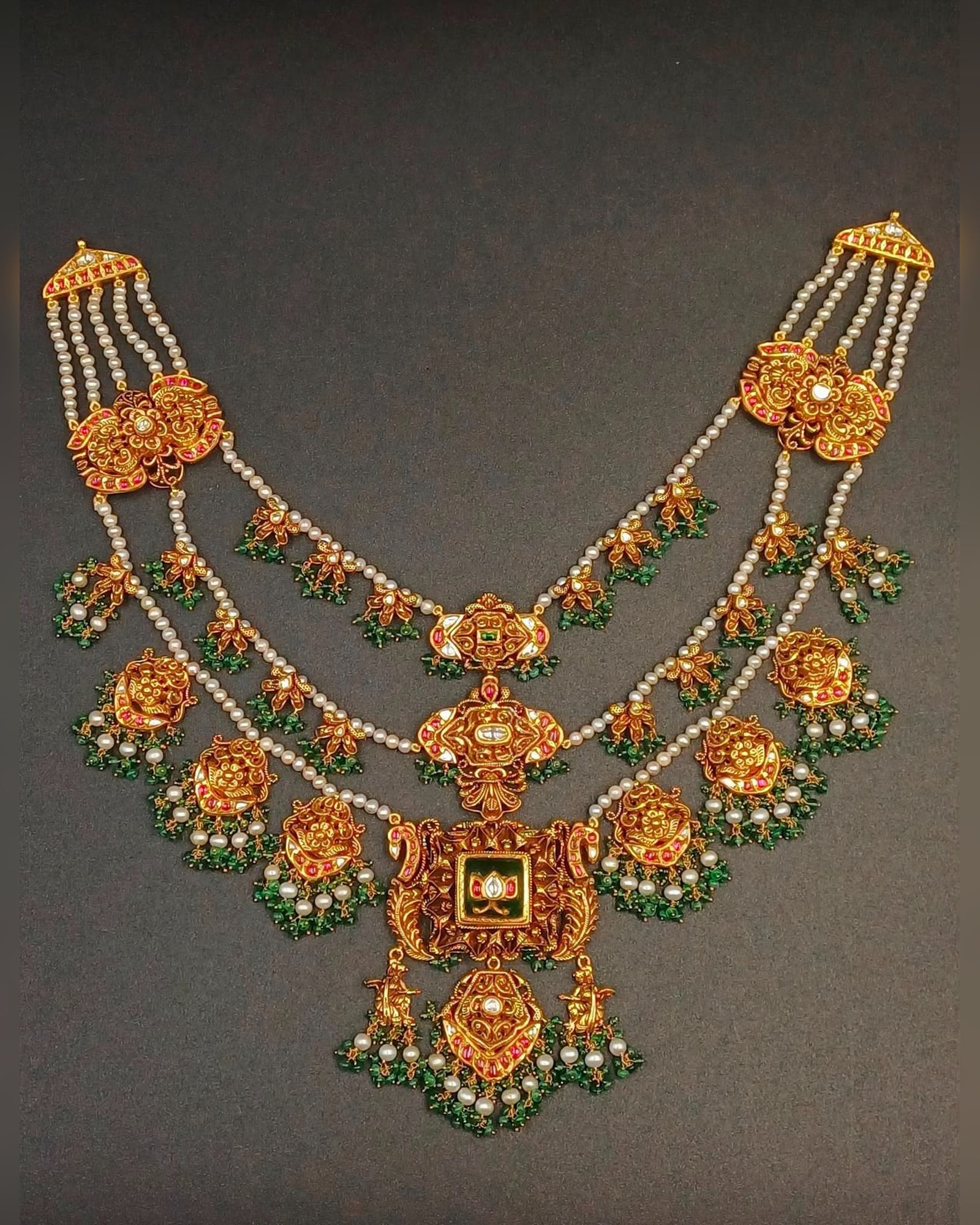 Gold necklace with pearl strands, green beads and temple motifs
